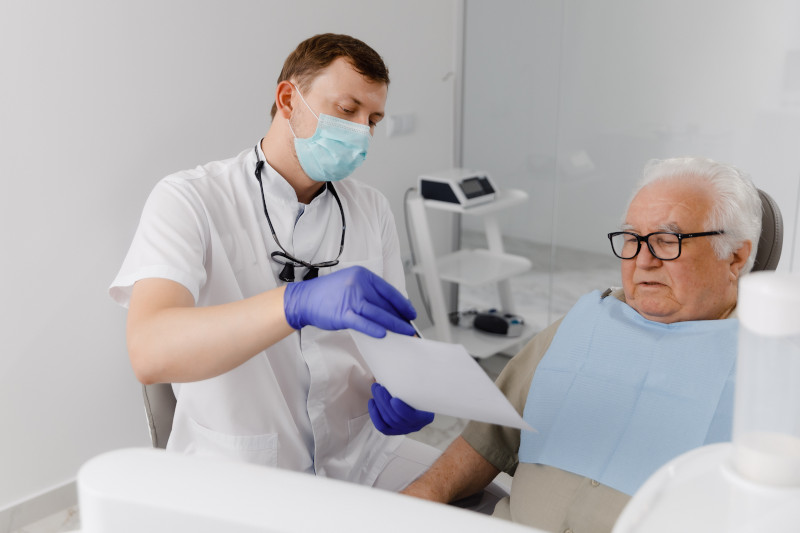 Dentist explaining a dental procedure to a patient from a form.